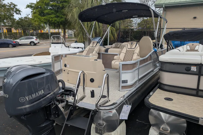 Slide: The Image of 2026 Trifecta 25 RFC SS pontoon boat with Yamaha engine, docked outdoors. - 12