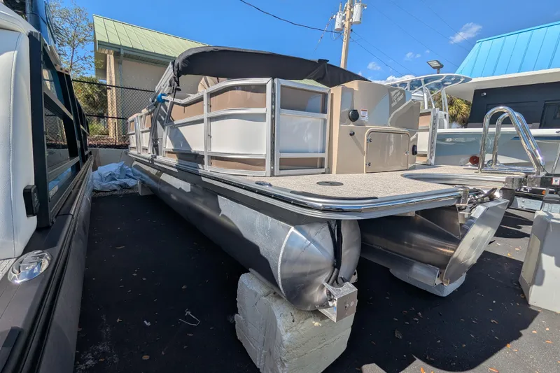 Slide: The Image of 2026 Trifecta 25 RFC SS pontoon boat displayed outdoors on a sunny day. - 2