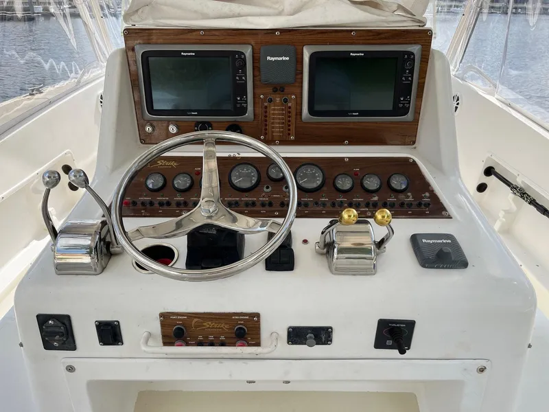 Slide: The Image of 2005 Strike 35 Sportfisherman helm with dual Raymarine displays and classic steering wheel. - 11