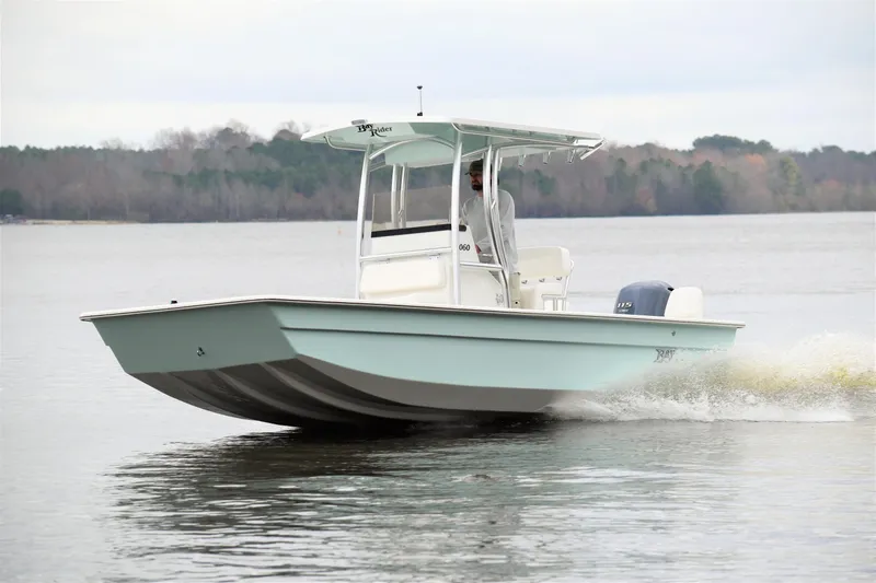 Slide: The Image of 2024 KenCraft 2060 Bay Rider Skiff cruising on a calm lake. - 2