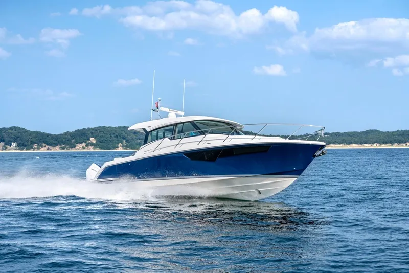 Slide: The Image of 2025 Tiara Yachts 43 LE cruising on open water under a clear blue sky. - 8