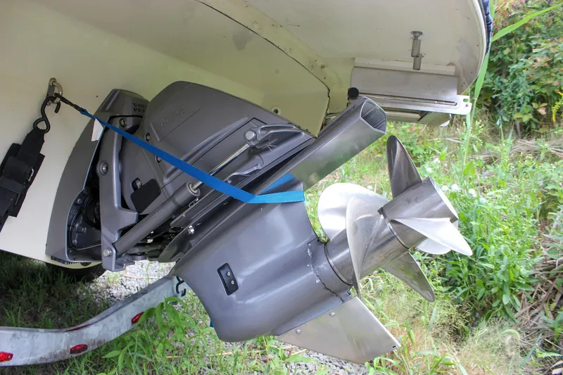 Slide: The Image of 2017 Chris-Craft Capri 27 boat on trailer, parked on grassy terrain. - 11