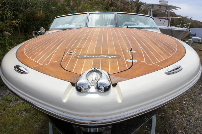 Slide: The Image of 2017 Chris-Craft Capri 27 boat propeller and engine detail, secured with a blue strap. - 13