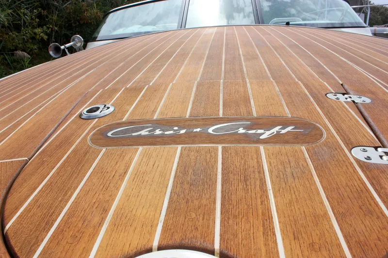 Slide: The Image of 2017 Chris-Craft Capri 27 boat with sleek wooden deck and chrome details. - 15