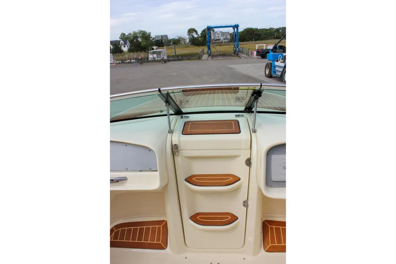 Slide: The Image of 2017 Chris-Craft Capri 27 boat dashboard with Garmin navigation and wooden steering wheel. - 27