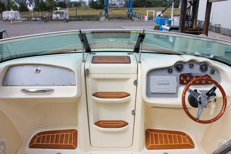 Slide: The Image of 2017 Chris-Craft Capri 27 interior with cream seating and wood accents. - 28