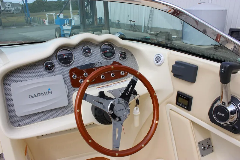 Slide: The Image of 2017 Chris-Craft Capri 27 boat interior with wood accents and windshield view. - 29
