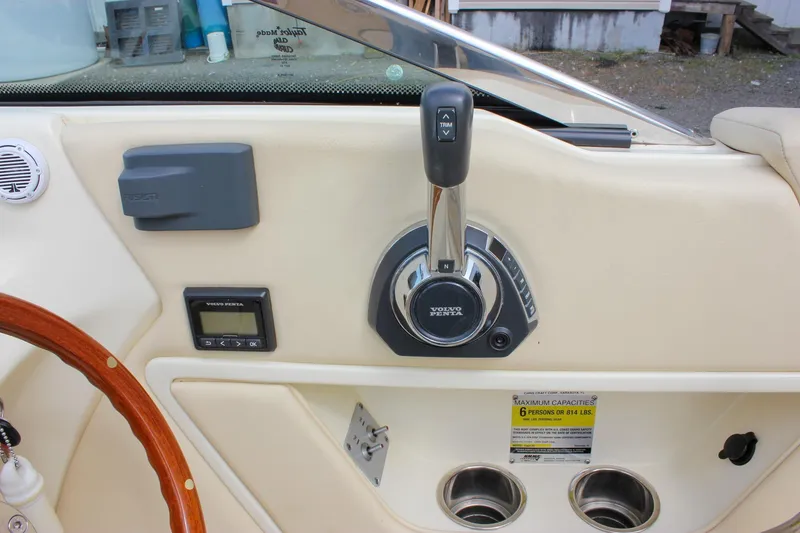 Slide: The Image of 2017 Chris-Craft Capri 27 boat dashboard with Garmin navigation and wooden steering wheel. - 30