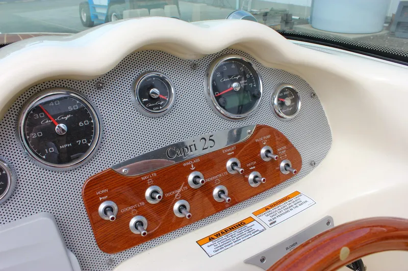 Slide: The Image of 2017 Chris-Craft Capri 27 dashboard with Garmin navigation and wooden steering wheel. - 31