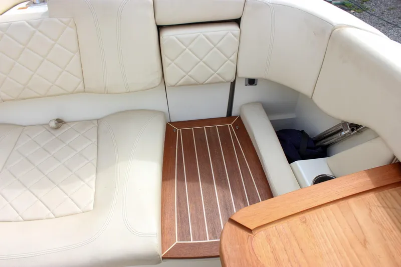 Slide: The Image of 2017 Chris-Craft Capri 27 boat interior with cream leather seating and wooden table. - 37