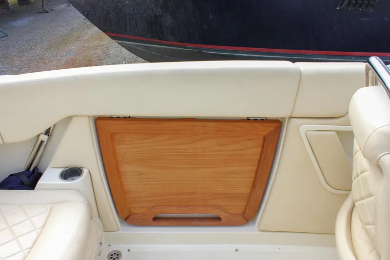 Slide: The Image of 2017 Chris-Craft Capri 27 interior with wood paneling, speaker, and cushioned seating. - 43