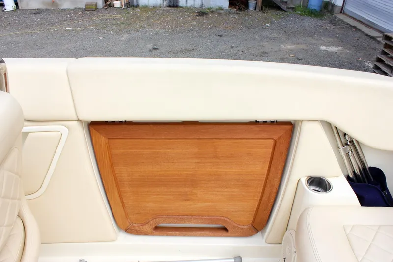 Slide: The Image of Interior of 2017 Chris-Craft Capri 27 boat, featuring white seating and wooden paneling. - 44