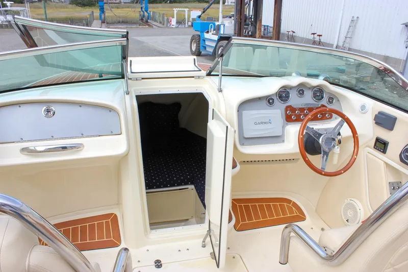 Slide: The Image of 2017 Chris-Craft Capri 27 interior with wood paneling and cream leather seating. - 45