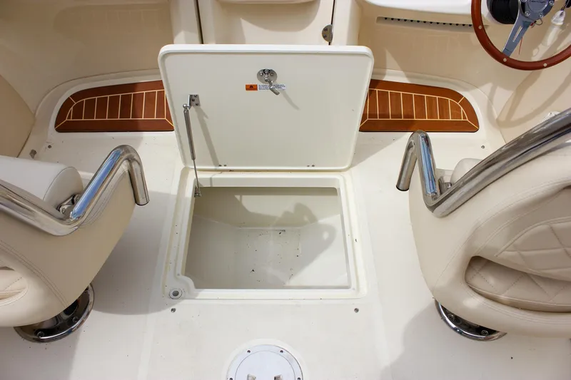 Slide: The Image of 2017 Chris-Craft Capri 27 boat interior with beige quilted upholstery in a workshop setting. - 56