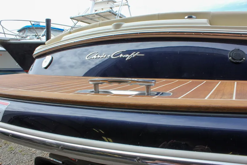 Slide: The Image of 2017 Chris-Craft Capri 27 storage compartment with beige quilted upholstery and equipment. - 59