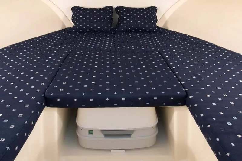 Slide: The Image of Manufacturer Provided Image: 2017 Chris-Craft Capri 25 cabin with blue patterned bedding and portable toilet. - 69
