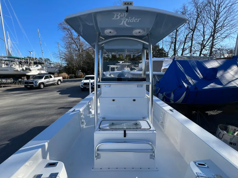 Slide: The Image of 2025 KenCraft 2260FS Bay Rider Skiff, center console, docked with boats and cars in the background. - 5