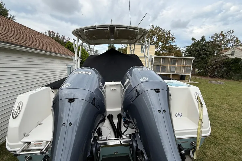 Slide: The Image of 2019 Sailfish 275 DC boat with dual Yamaha outboard motors in a backyard setting. - 11