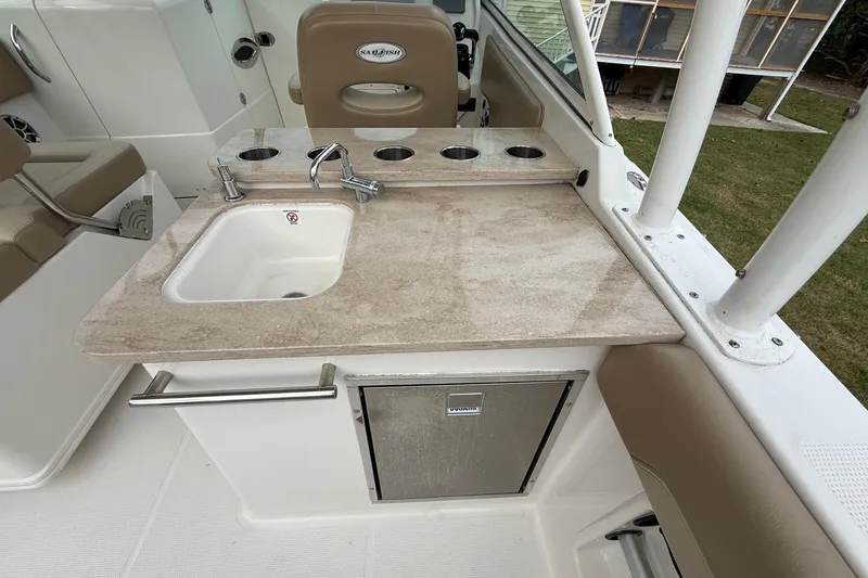 Slide: The Image of 2019 Sailfish 275 DC boat interior with sink, faucet, and storage compartment. - 12