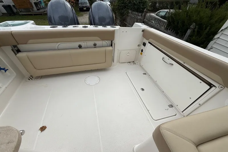 Slide: The Image of 2019 Sailfish 275 DC boat interior with beige seating and storage compartments. - 16