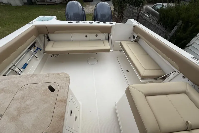 Slide: The Image of 2019 Sailfish 275 DC boat interior with beige seating and dual outboard motors. - 17