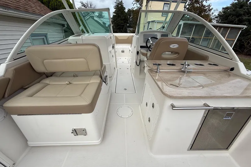 Slide: The Image of 2019 Sailfish 275 DC boat interior with beige seating and kitchenette area. - 21
