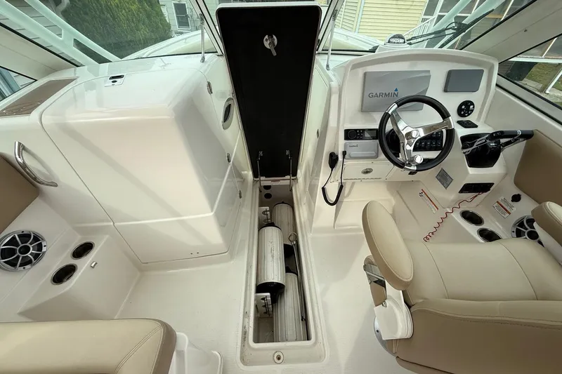 Slide: The Image of 2019 Sailfish 275 DC boat interior with Garmin navigation system and beige seating. - 23