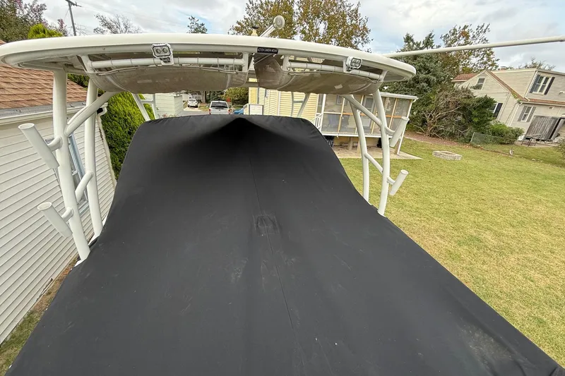 Slide: The Image of 2019 Sailfish 275 DC boat with black cover, parked in residential yard. - 29