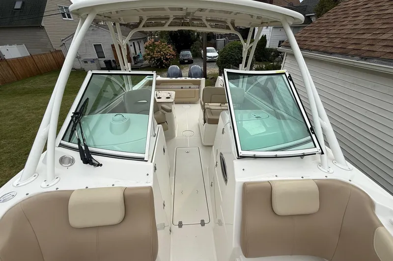 Slide: The Image of 2019 Sailfish 275 DC boat with open deck, beige seating, and dual windshields. - 32
