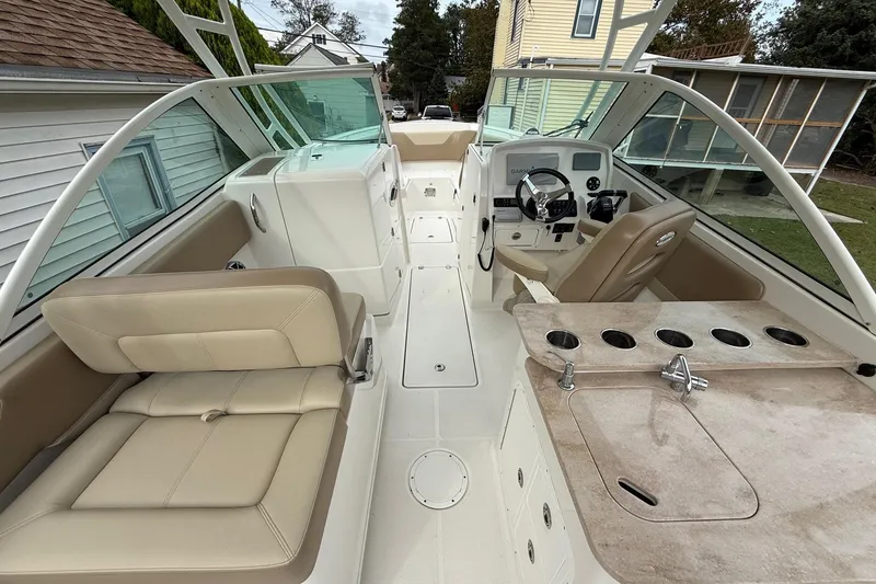 Slide: The Image of 2019 Sailfish 275 DC boat interior with seating, steering console, and cup holders. - 34