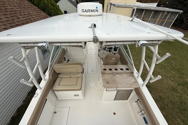Slide: The Image of 2019 Sailfish 275 DC boat interior with seating, rod holders, and Garmin equipment. - 7