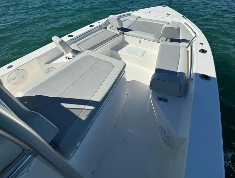 Slide: The Image of 2025 KenCraft 269 Bay boat interior with cushioned seating on the water. - 7