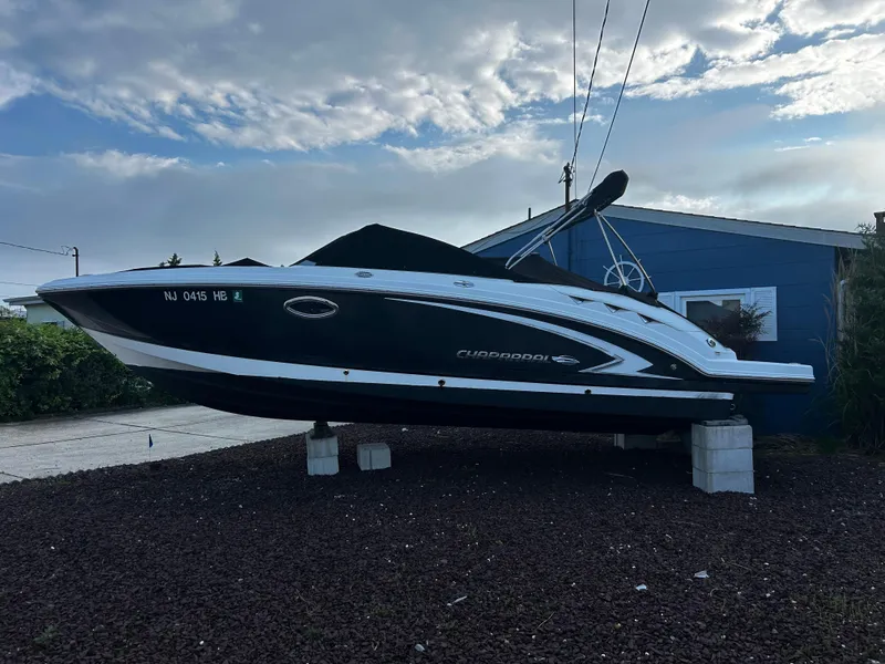 Slide: The Image of 2008 Chaparral Sunesta 244 boat on blocks, parked beside a blue building. - 2