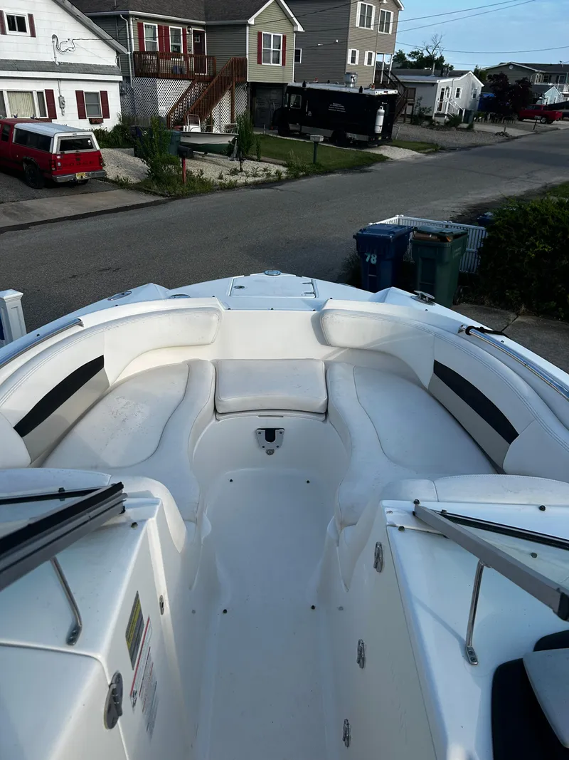 Slide: The Image of 2008 Chaparral Sunesta 244 boat interior with white seating, parked in a residential area. - 20