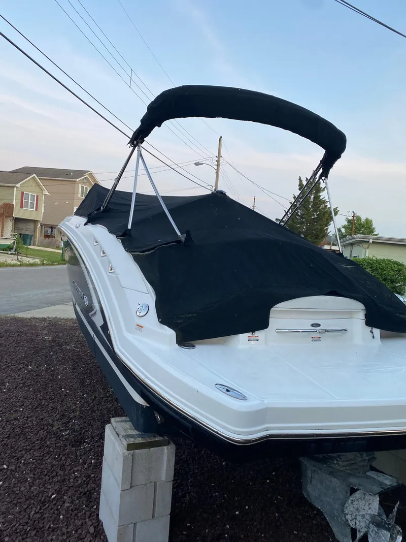 Slide: The Image of 2008 Chaparral Sunesta 244 boat with black cover, parked on blocks. - 5