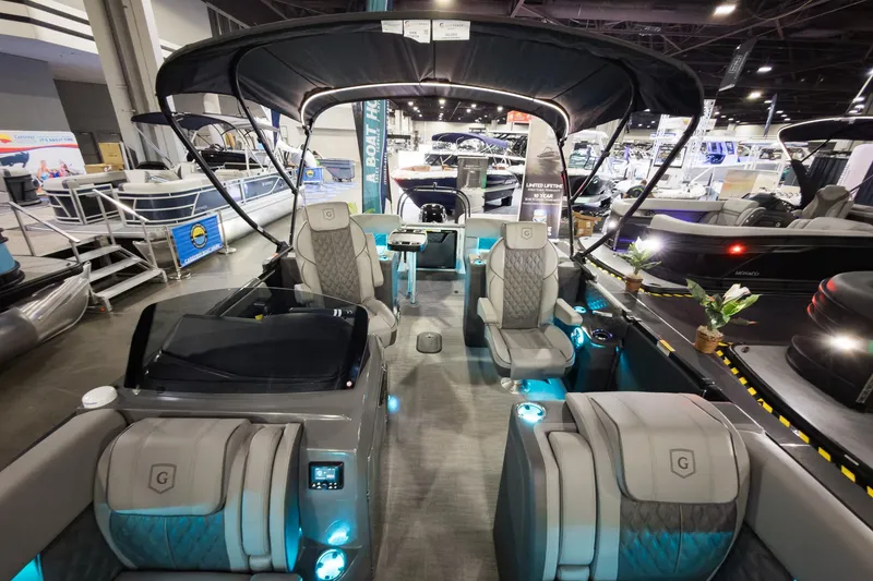 Slide: The Image of 2026 Godfrey Sanpan 23' Split Bench pontoon boat interior at a boat show. - 13