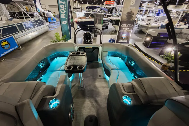 Slide: The Image of 2026 Godfrey Sanpan 23' Split Bench pontoon boat interior with ambient lighting at a boat show. - 25