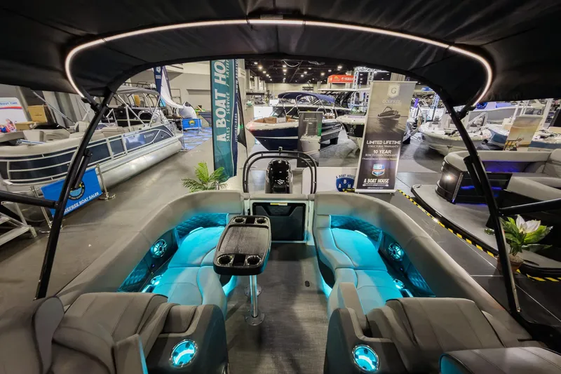 Slide: The Image of 2026 Godfrey Sanpan 23' Split Bench 2300 SBC at a boat show, featuring illuminated seating. - 27