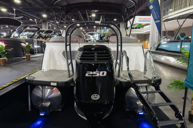 Slide: The Image of 2026 Godfrey Sanpan 23' Split Bench pontoon boat with 250 horsepower engine at a boat show. - 7