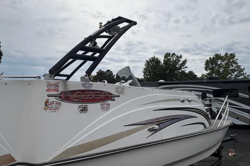 Slide: The Image of 2017 Razor 238 PF XL boat with decals, parked outdoors under cloudy sky. - 6