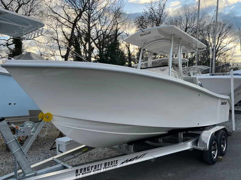 The Image of 2024 KenCraft 21 boat on trailer, parked outdoors, with trees in the background. - 0