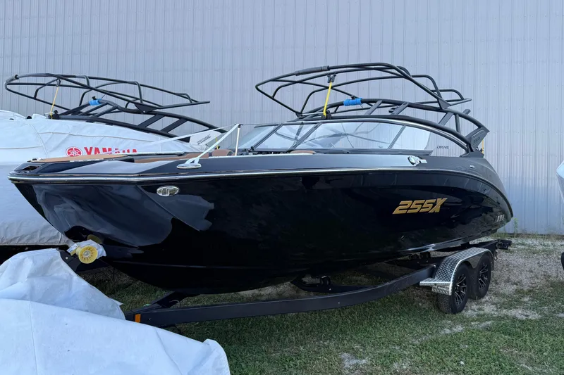 The Image of 2026 Yamaha Boats 255XD, sleek black design, parked on a trailer outdoors. - 0