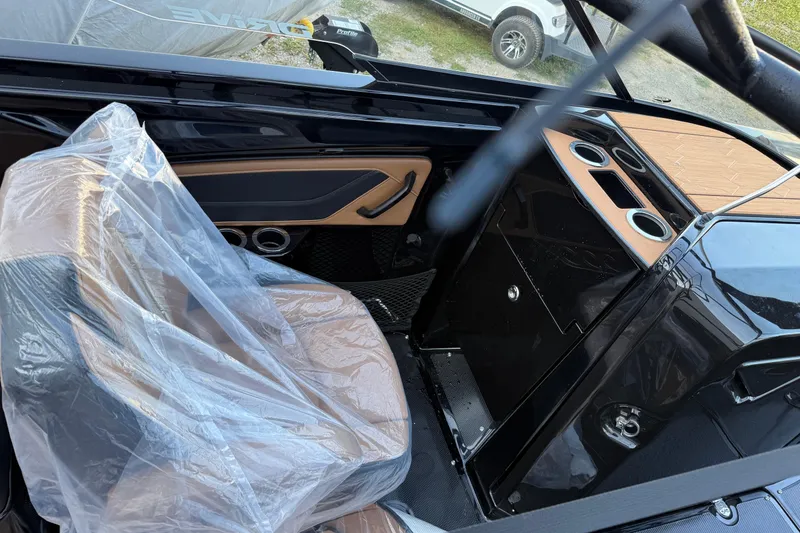 Slide: The Image of Interior of 2026 Yamaha Boats 255XD, featuring sleek black and tan design with covered seating. - 6