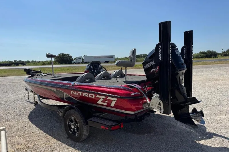 Slide: The Image of 2013 Nitro Z7 SC boat with Mercury engine, parked on gravel, under clear blue sky. - 10