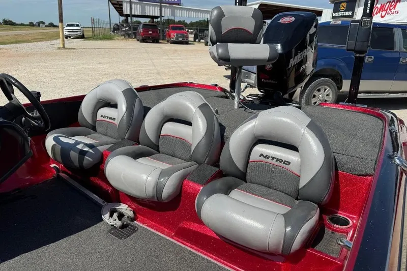 Slide: The Image of 2013 Nitro Z7 SC boat interior with gray and red seating, parked outdoors. - 6