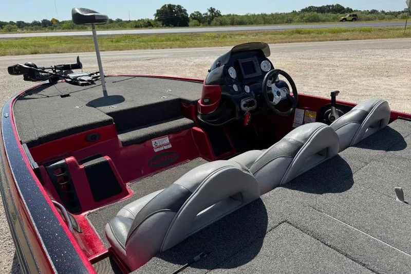 Slide: The Image of 2013 Nitro Z7 SC boat interior with steering wheel and seating, parked on a sunny day. - 8