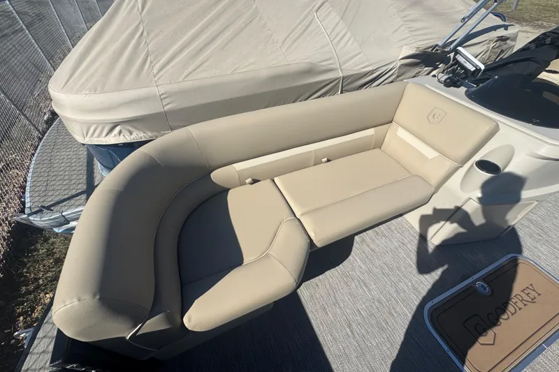 Slide: The Image of 2026 Godfrey Xperience 2286 SBX boat interior with beige seating and covered deck. - 16