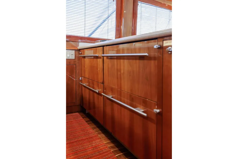Slide: The Image of Wooden cabinetry in 2005 Hatteras 50 Convertible yacht interior, featuring sleek metal handles. - 23