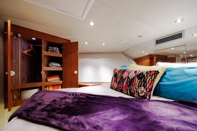 Slide: The Image of Luxurious bedroom interior of 2005 Hatteras 50 Convertible yacht with colorful pillows and open closet. - 39