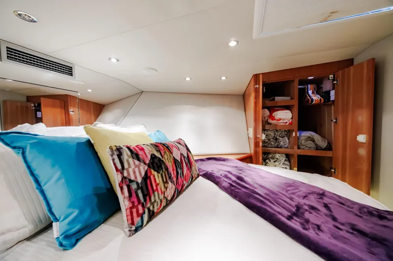 Slide: The Image of Luxurious cabin interior of 2005 Hatteras 50 Convertible yacht with colorful pillows and open closet. - 40